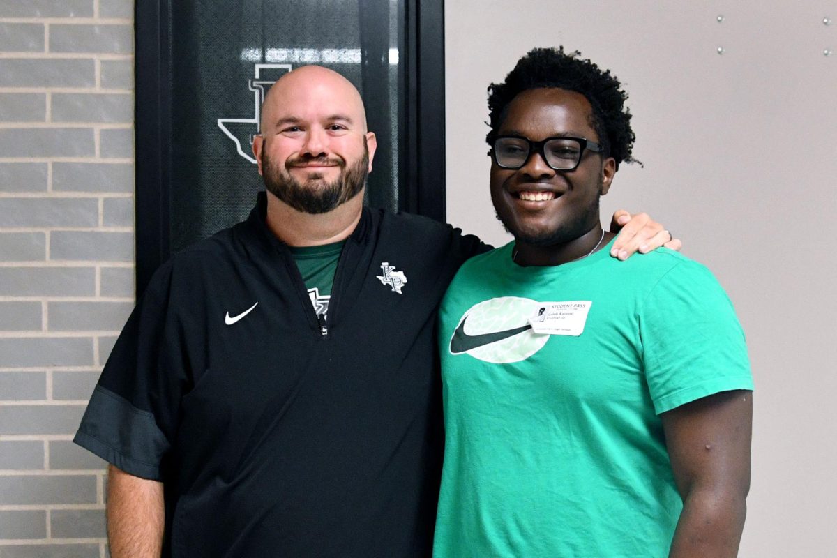Coach Sean Bright works with junior Caleb Kazeem on the defensive side of the ball in football. Kazeem first met Bright during his first practice sophomore year.