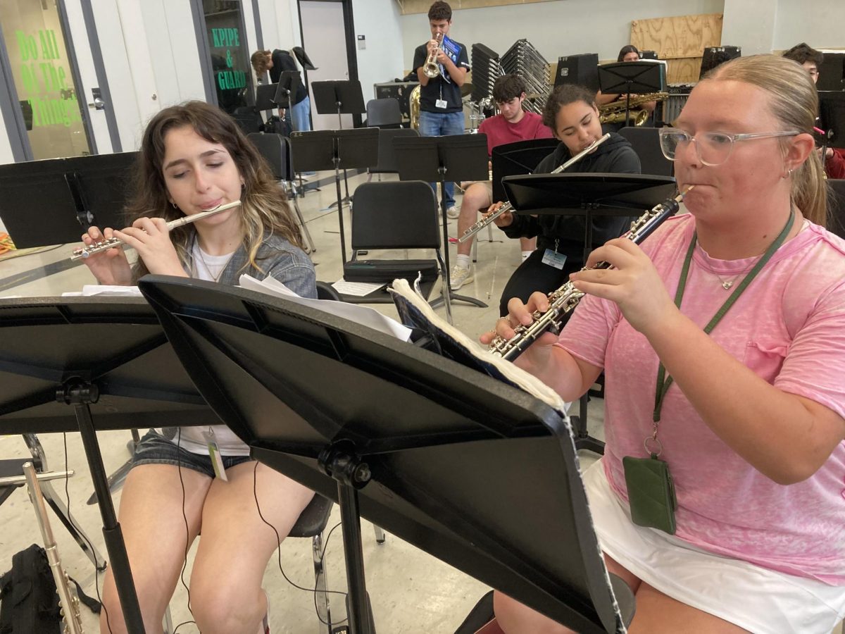 Senior Selva Al Khalil and freshman Isabella Garcia practice together during after school band rehearsal in May.