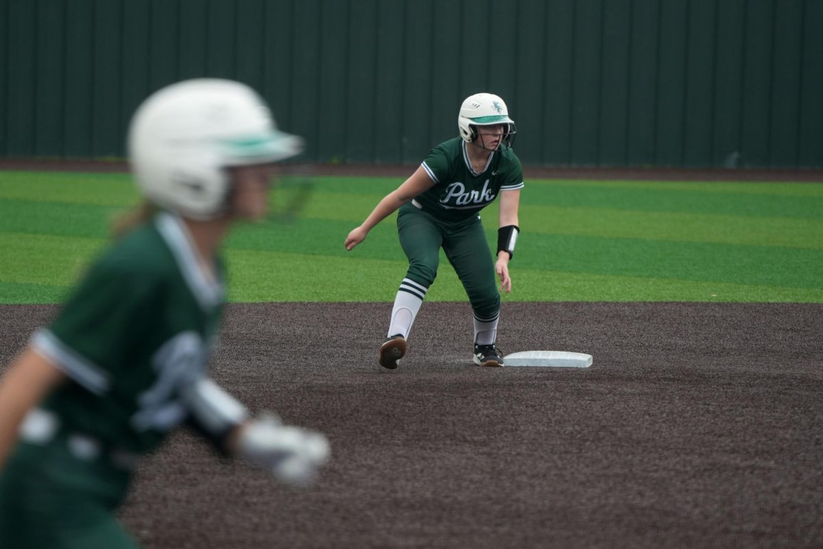 With freshman Hailie Messina standing on third base, freshman Delilah Wright watches the batter box in an attempt to run the bases. The softball team won the game against Friendswood, 5-0. 