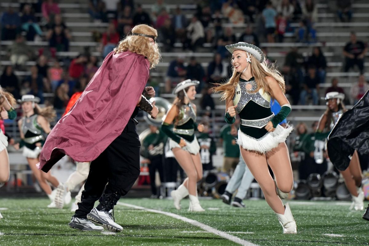 Senior Annaleise Kimmel smiles while running in a circle as part of the Bob and Sue Silver Stars dance performed at halftime. The annual Bob and Sue dance was performed at the game against Porter on Nov. 6.