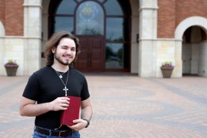 Junior Luke Goss stands outside of St. Martha Catholic Church, just 1.2 miles from Kingwood Park High School. Goss was baptized and confirmed in the church a year ago and has set his sights on becoming a priest. 